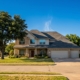 Suburban North Dallas home with an asphalt-shingle roof under intense summer sun